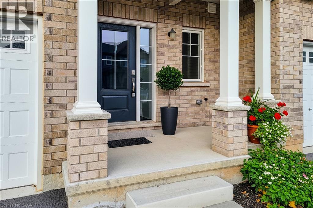 Brick facade entry with a dark panel door featuring multi-pane glass - 111 Alicia Crescent, Thorold, ON
