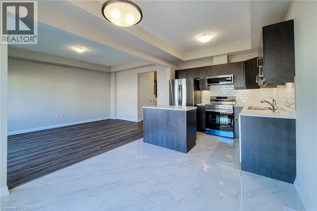 Contemporary kitchen with dark wood-finish cabinetry, stainless steel appliances, and a subway tile backsplash - 111 Alicia Crescent, Thorold, ON