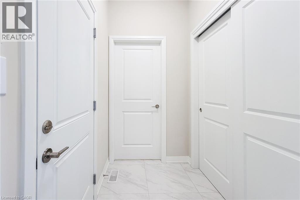 Hallway featuring light-toned walls, white trim, and white panel doors - 111 Alicia Crescent, Thorold, ON