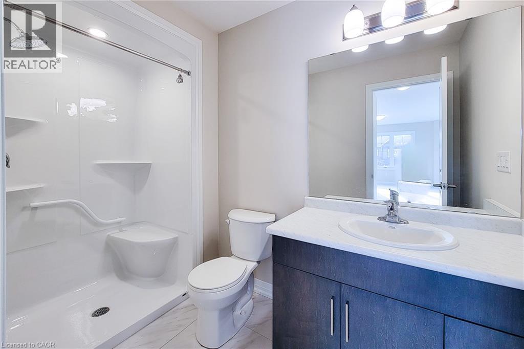 Full bathroom featuring a walk-in shower with built-in seating and grab bar, a single vanity with dark wood-finish cabinetry, a white countertop, and a large wall-mounted mirror - 111 Alicia Crescent, Thorold, ON