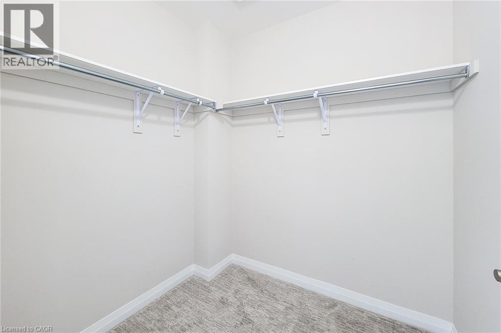 Walk-in closet featuring white wall shelving and integrated hanging rods - 111 Alicia Crescent, Thorold, ON