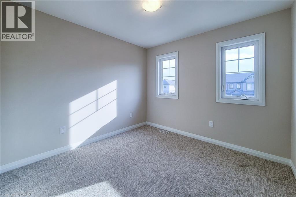 Neutral-toned room with broadloom carpeting and two multi-pane windows - 111 Alicia Crescent, Thorold, ON