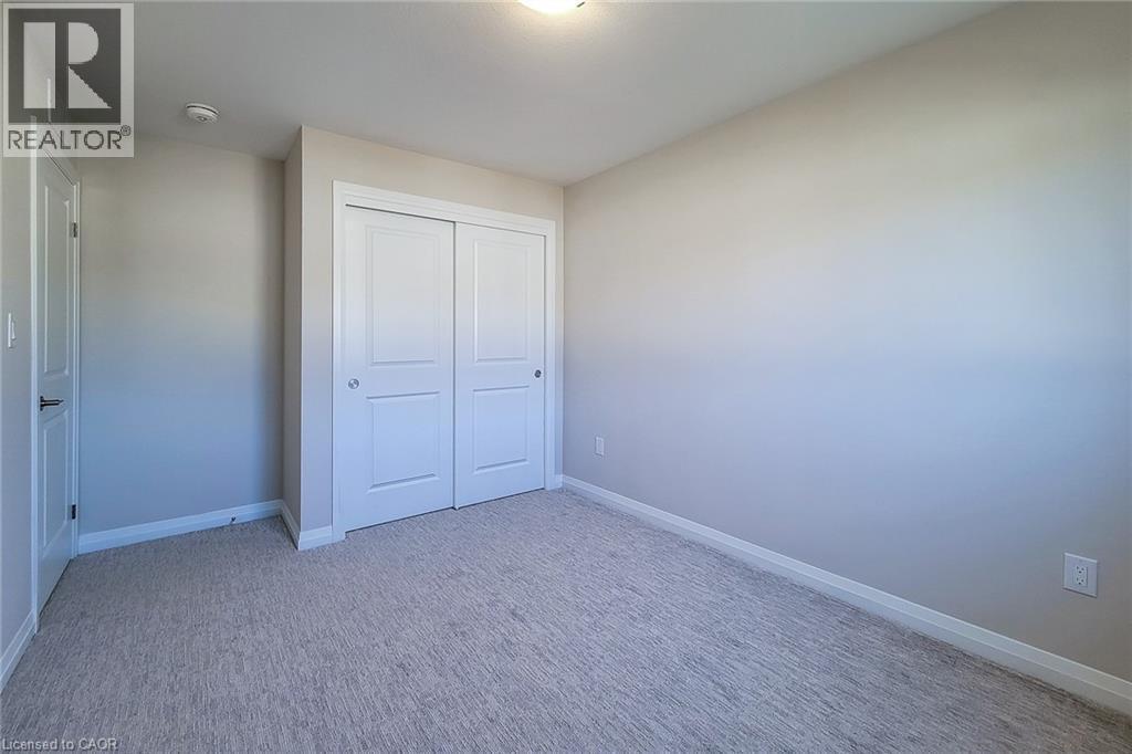 Room featuring light gray painted walls, a textured gray carpet, white trim work, and a white bi-fold closet door - 111 Alicia Crescent, Thorold, ON