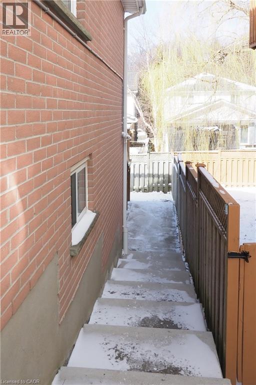 Exterior access staircase featuring concrete steps and a brick-clad wall - 67 Hollyridge Crescent Unit# Lower, Kitchener, ON - Outdoor With Exterior