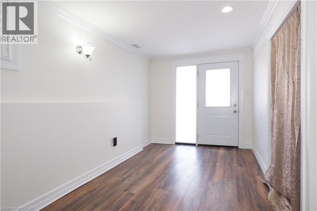 Room featuring wood-finish flooring, white baseboards, and crown molding - 67 Hollyridge Crescent Unit# Lower, Kitchener, ON - Indoor Photo Showing Other Room