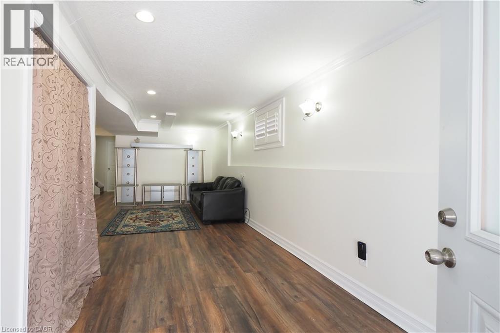 Finished basement area featuring wood-finish flooring, recessed lighting, and wall sconces - 67 Hollyridge Crescent Unit# Lower, Kitchener, ON - Indoor Photo Showing Other Room
