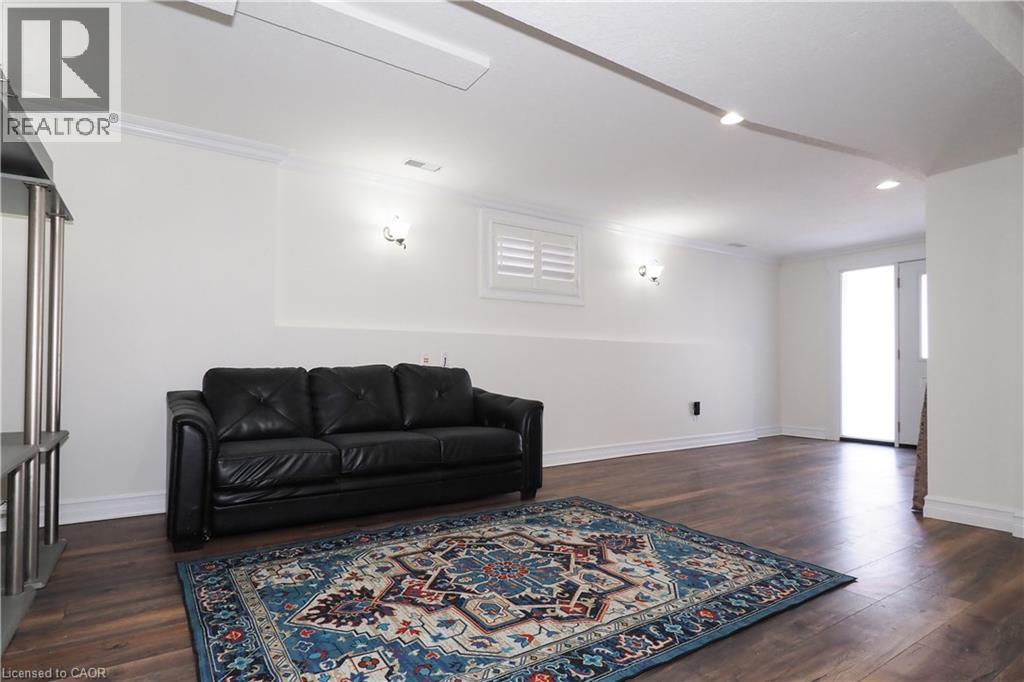 Spacious room featuring wood-finish flooring, white walls, and a recessed lighting track - 67 Hollyridge Crescent Unit# Lower, Kitchener, ON - Indoor Photo Showing Living Room