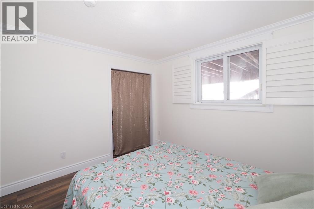 Interior room featuring wood-finish flooring, white baseboards, and crown molding - 67 Hollyridge Crescent Unit# Lower, Kitchener, ON - Indoor Photo Showing Bedroom