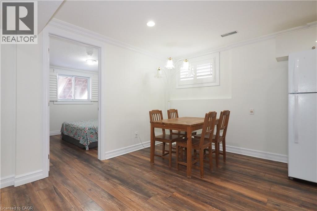 Wood-finish flooring throughout, complemented by white trim and crown molding - 67 Hollyridge Crescent Unit# Lower, Kitchener, ON - Indoor Photo Showing Dining Room