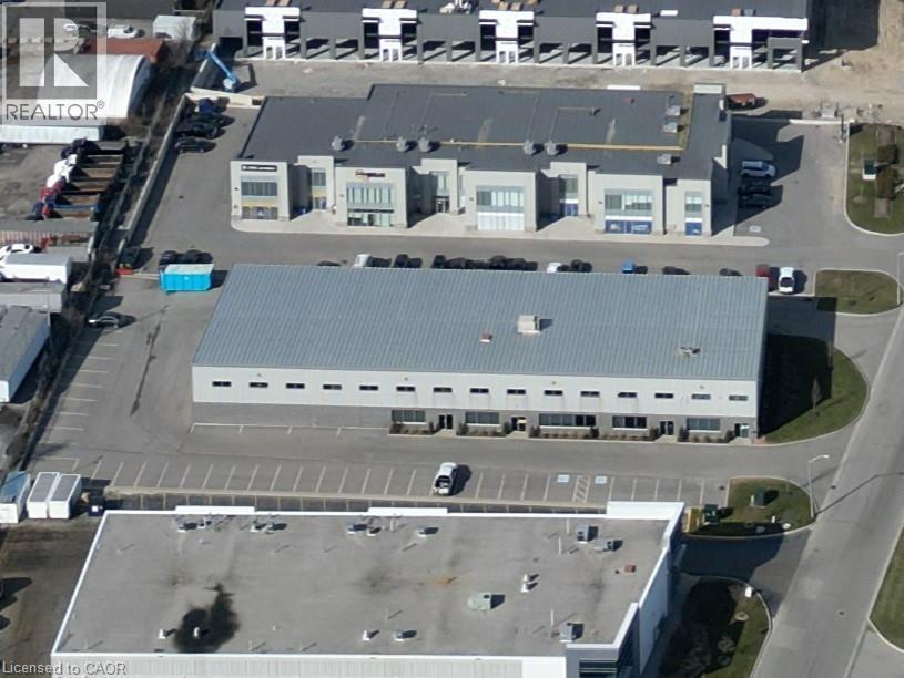 Industrial building with a metal roof, multiple loading dock doors, and an expansive paved parking area - 44 Ditton Drive Unit# 3, Hamilton, ON
