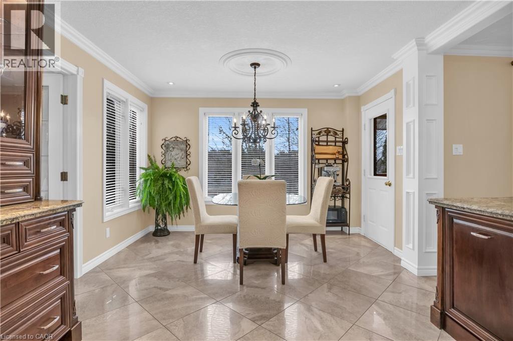 Dining area featuring large windows, crown molding, and diagonal tile flooring - 228 Michener Crescent, Kitchener, ON - Indoor Photo Showing Dining Room