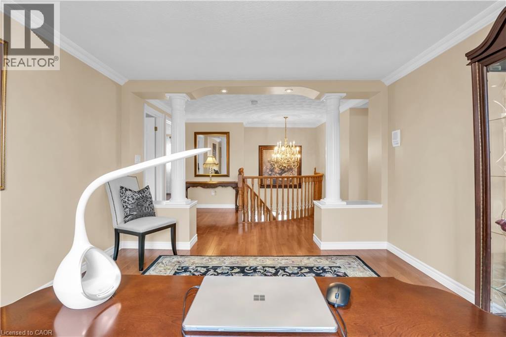 Archway entry to a hardwood flooring hallway with a staircase featuring wooden railings - 228 Michener Crescent, Kitchener, ON - Indoor Photo Showing Other Room