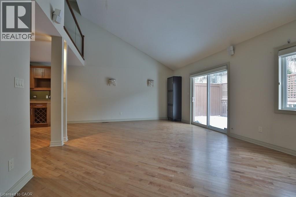 Spacious room featuring wood-finish flooring and a vaulted ceiling - 7 Gibson Place Unit# 21, St. Catharines, ON - Indoor Photo Showing Other Room