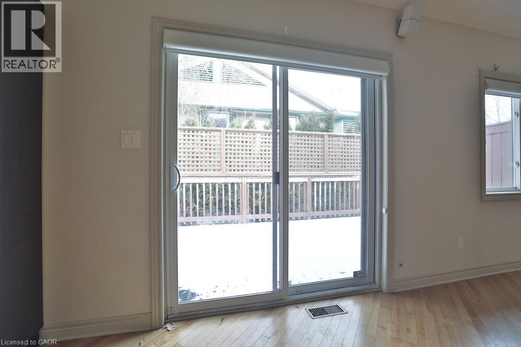 Sliding glass door leading to an outdoor deck with lattice privacy screening - 7 Gibson Place Unit# 21, St. Catharines, ON - Indoor Photo Showing Other Room
