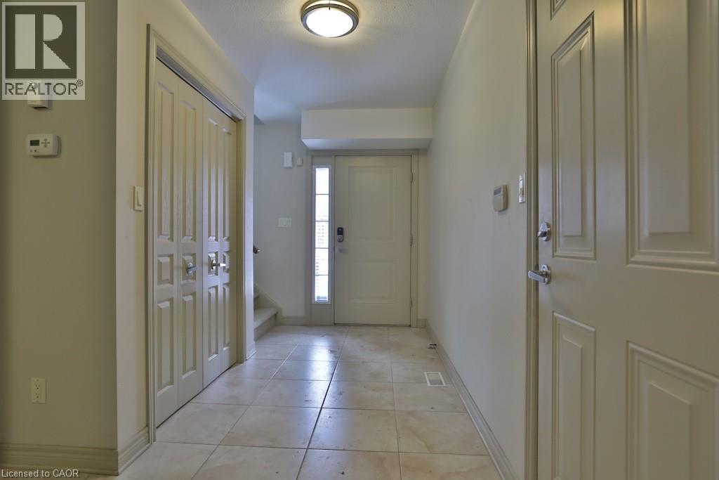 Entryway featuring neutral-toned tile flooring, flush mount ceiling light, and a paneled entry door with frosted glass sidelight - 7 Gibson Place Unit# 21, St. Catharines, ON - Indoor Photo Showing Other Room