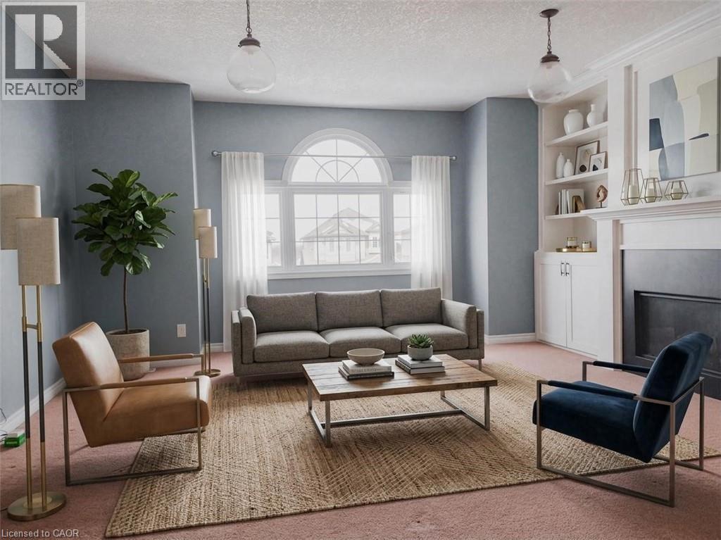 Living space featuring a prominent arched window, built-in shelving, a fireplace, and overhead pendant lighting. Virtually staged. - 569 Activa Avenue, Kitchener, ON - Indoor Photo Showing Living Room With Fireplace