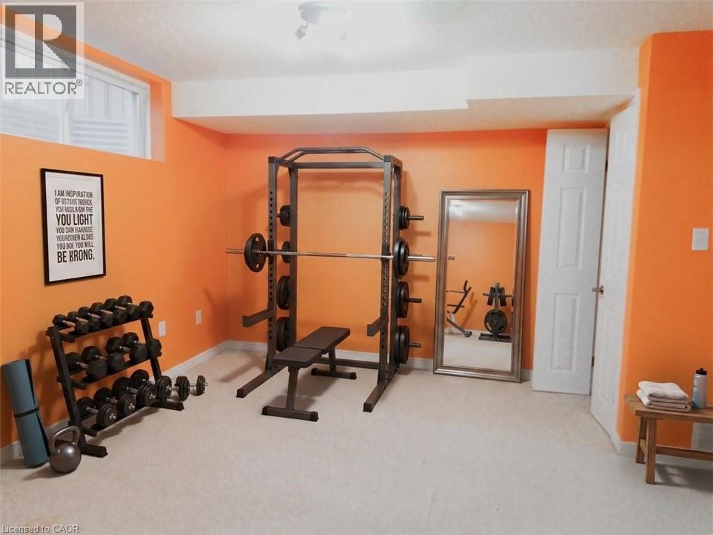 Basement rec area carpeted room featuring vibrant orange walls and white trim - 569 Activa Avenue, Kitchener, ON - Indoor Photo Showing Gym Room