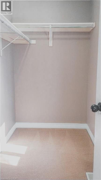 Interior closet featuring a single hanging rod, upper shelf, and carpet flooring - 569 Activa Avenue, Kitchener, ON - Indoor With Storage