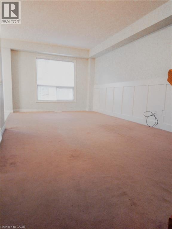 Spacious room featuring carpeting, a single window with blinds, and white wainscoting - 569 Activa Avenue, Kitchener, ON - Indoor Photo Showing Other Room