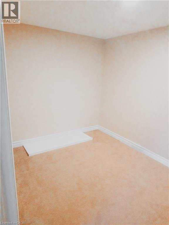 Carpeted flooring with light-toned walls and crisp white baseboards - 569 Activa Avenue, Kitchener, ON - Indoor Photo Showing Other Room