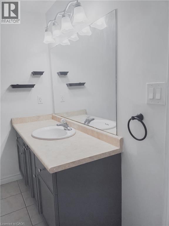 Bathroom vanity with a light-toned countertop and integrated sink basin - 569 Activa Avenue, Kitchener, ON - Indoor Photo Showing Bathroom