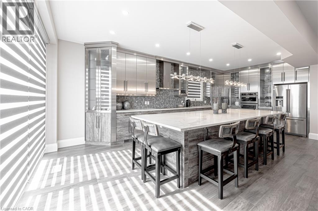 Kitchen featuring decorative light fixtures, modern cabinets, wall chimney range hood, appliances with stainless steel finishes, and decorative backsplash - 477 Blair Creek Drive, Kitchener, ON - Indoor Photo Showing Other Room