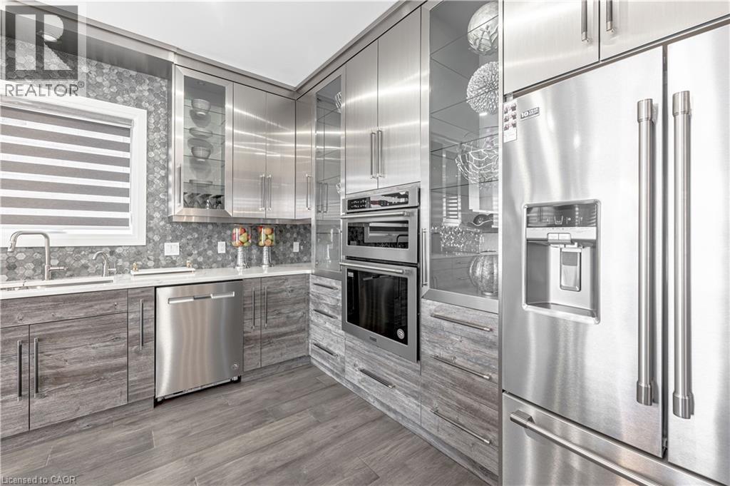 Kitchen featuring glass insert cabinets, light countertops, modern cabinets, stainless steel appliances, and a sink - 477 Blair Creek Drive, Kitchener, ON - Indoor Photo Showing Kitchen With Upgraded Kitchen