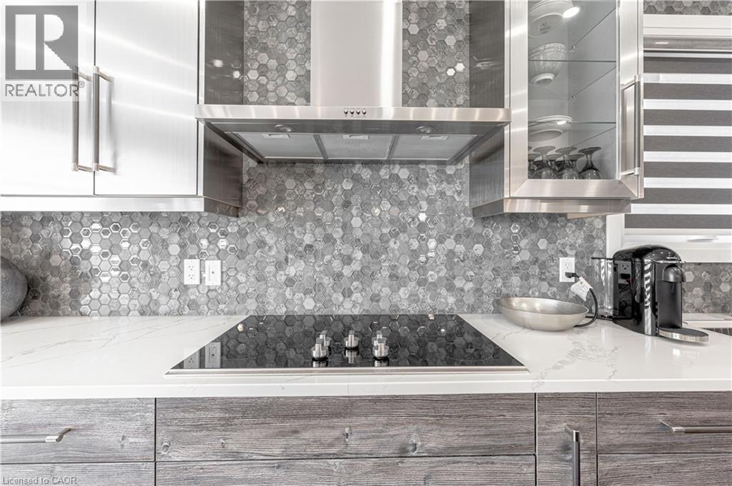 Kitchen featuring decorative backsplash, wall chimney exhaust hood, black electric stovetop, and modern cabinets - 477 Blair Creek Drive, Kitchener, ON - Indoor Photo Showing Kitchen With Upgraded Kitchen