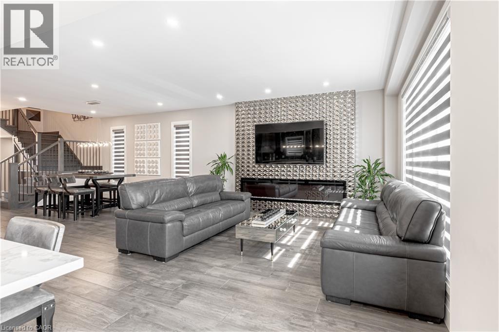 Living room with a tile fireplace, recessed lighting, stairway, and light wood-style floors - 477 Blair Creek Drive, Kitchener, ON - Indoor Photo Showing Living Room With Fireplace