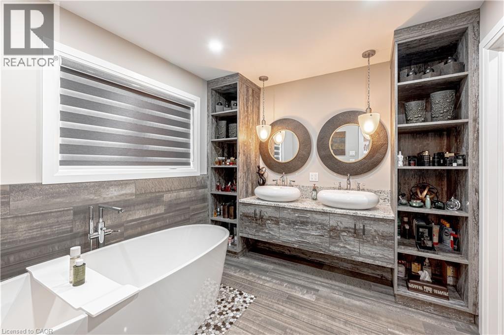 Full bath featuring a freestanding bath, double vanity, a sink, and ceramic tile finished floors - 477 Blair Creek Drive, Kitchener, ON - Indoor Photo Showing Bathroom