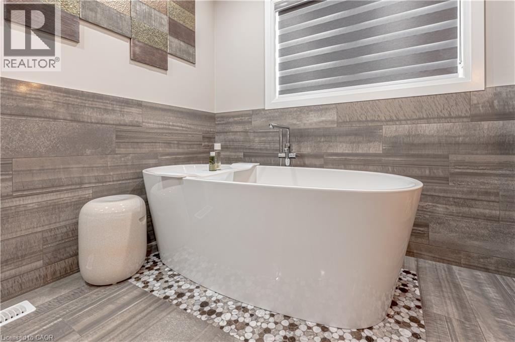 Bathroom with a soaking tub, tile walls, and wainscoting - 477 Blair Creek Drive, Kitchener, ON - Indoor
