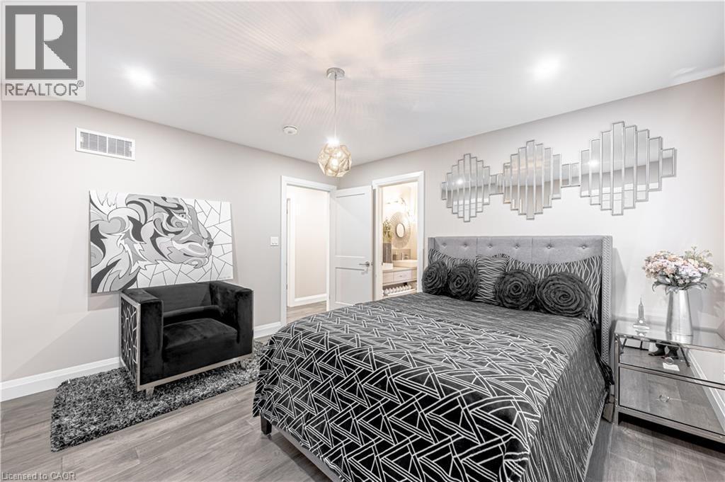 Bedroom featuring visible vents, baseboards, connected bathroom, and wood finished floors - 477 Blair Creek Drive, Kitchener, ON - Indoor Photo Showing Bedroom