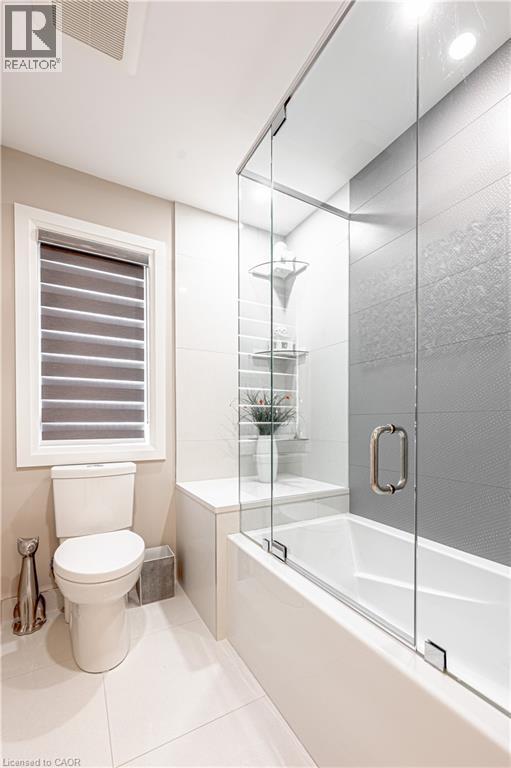 Full bathroom featuring tile patterned flooring, toilet, combined bath / shower with glass door, and visible vents - 477 Blair Creek Drive, Kitchener, ON - Indoor Photo Showing Bathroom
