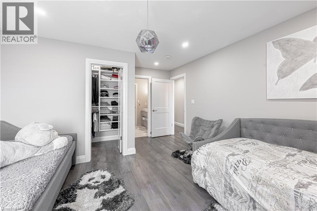 Bedroom featuring a closet, baseboards, a walk in closet, and wood finished floors - 477 Blair Creek Drive, Kitchener, ON - Indoor Photo Showing Bedroom