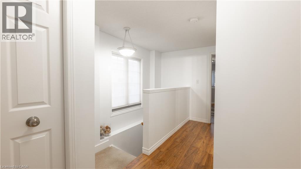 Hall with baseboards, an upstairs landing, and wood finished floors - 85 Bankside Drive Unit# E34, Kitchener, ON - Indoor Photo Showing Other Room