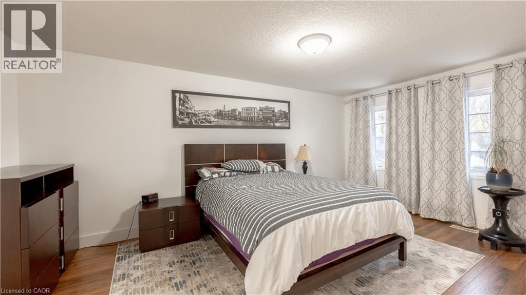 Bedroom with a textured ceiling, baseboards, and wood finished floors - 85 Bankside Drive Unit# E34, Kitchener, ON - Indoor Photo Showing Bedroom