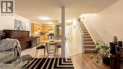 Kitchen featuring under cabinet range hood, light countertops, appliances with stainless steel finishes, light brown cabinetry, and tasteful backsplash -