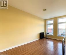 Room featuring wood-finish flooring, light-colored walls, and a white ceiling with a flush-mount light fixture -