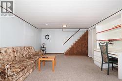 Carpeted recreational room featuring light-colored walls and a drop ceiling -