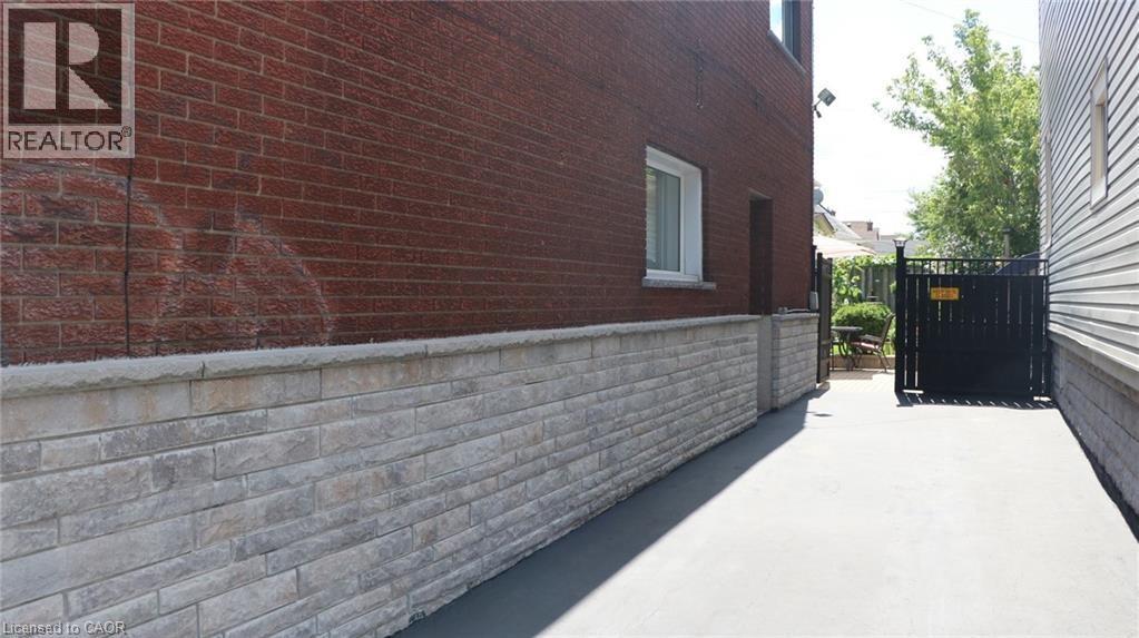 Side exterior with red brick and stone veneer siding - 1476 Barton Street E, Hamilton, ON - Outdoor With Exterior