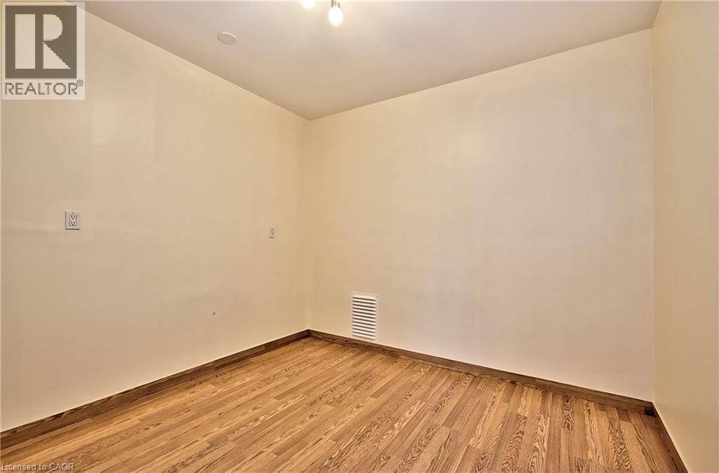 Room featuring wood-finish flooring, baseboard trim, and light-toned wall paint - 1476 Barton Street E, Hamilton, ON - Indoor Photo Showing Other Room