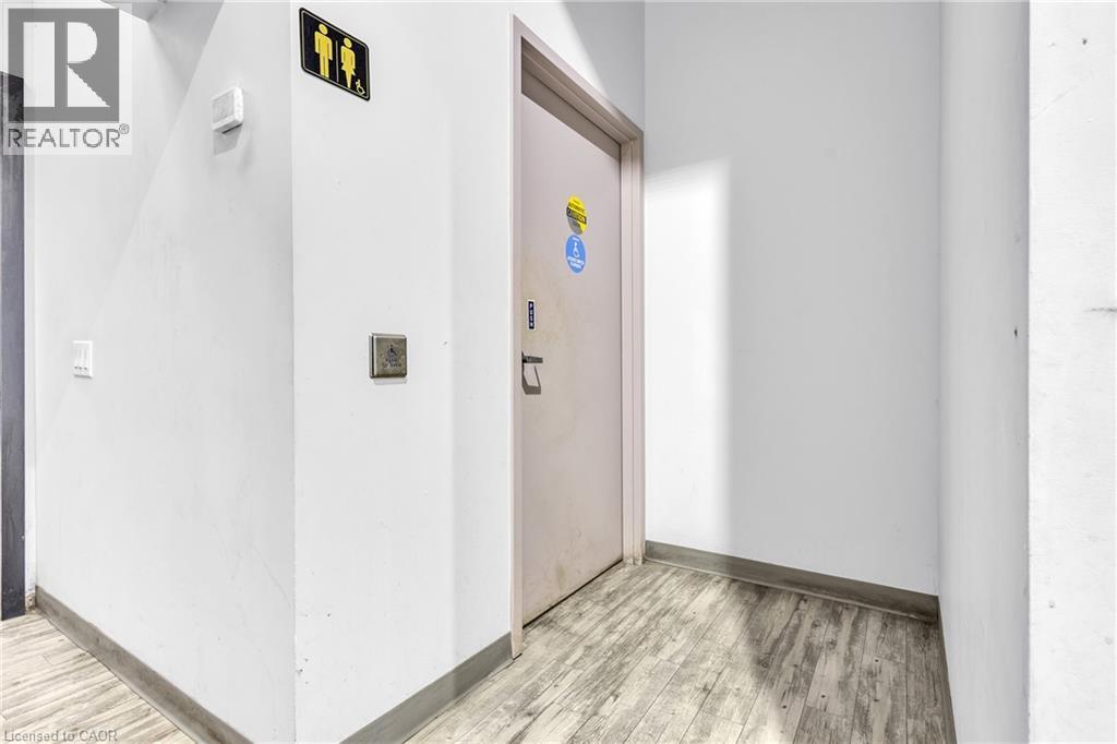 Entryway featuring light-colored wood-finish flooring, white painted walls, and a light-colored door with a security keypad - 545 Hespeler Road, Cambridge, ON