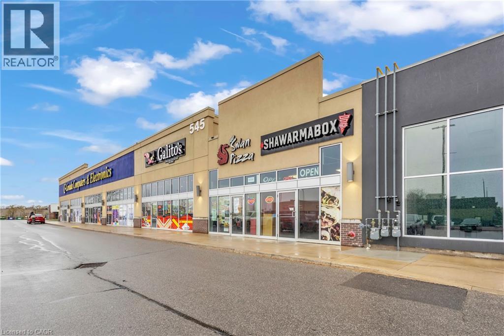 Commercial storefronts featuring large display windows and prominent signage - 545 Hespeler Road, Cambridge, ON