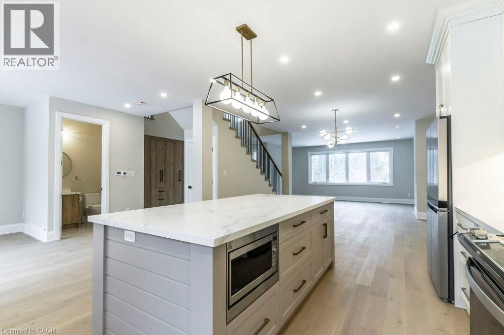 Kitchen featuring open floor plan, a kitchen island, stainless steel appliances, light stone countertops, and light wood-style floors - 1105 Main Street E, Cambridge, ON - Indoor Photo Showing Kitchen With Upgraded Kitchen