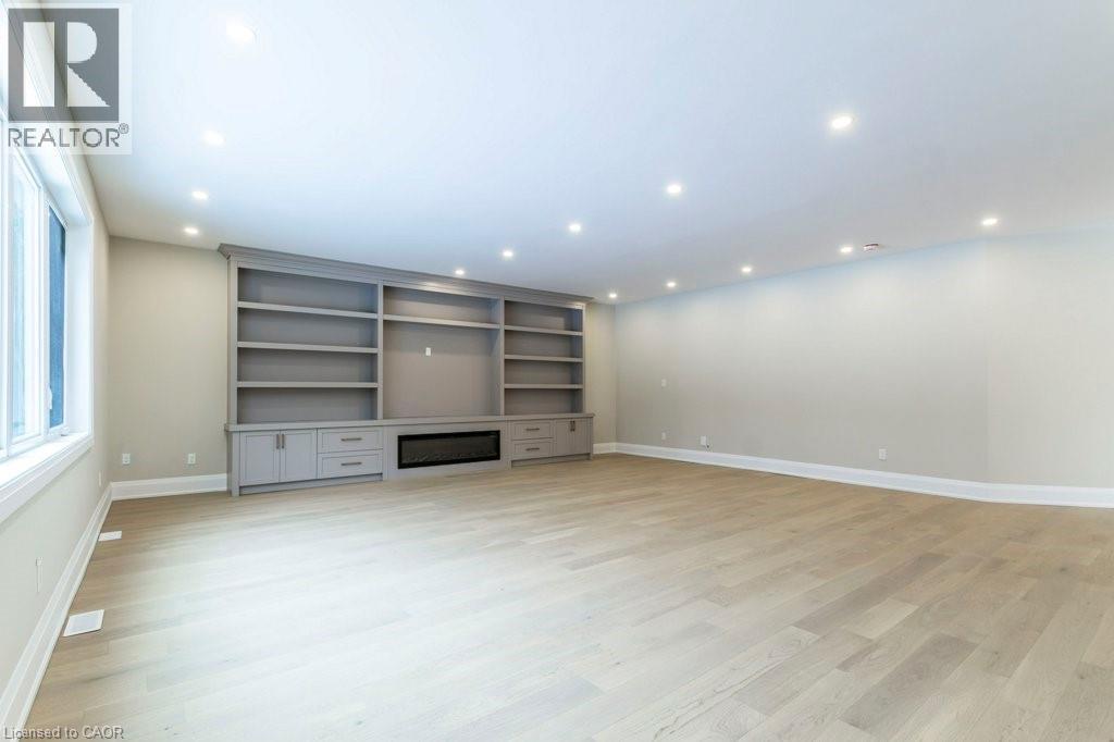 Unfurnished living room featuring light wood-style flooring, recessed lighting, and a glass covered fireplace - 1105 Main Street E, Cambridge, ON - Indoor Photo Showing Other Room