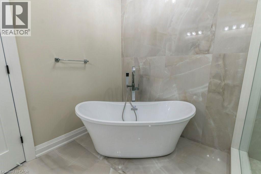 Bathroom featuring a freestanding bath and baseboards - 1105 Main Street E, Cambridge, ON - Indoor Photo Showing Bathroom