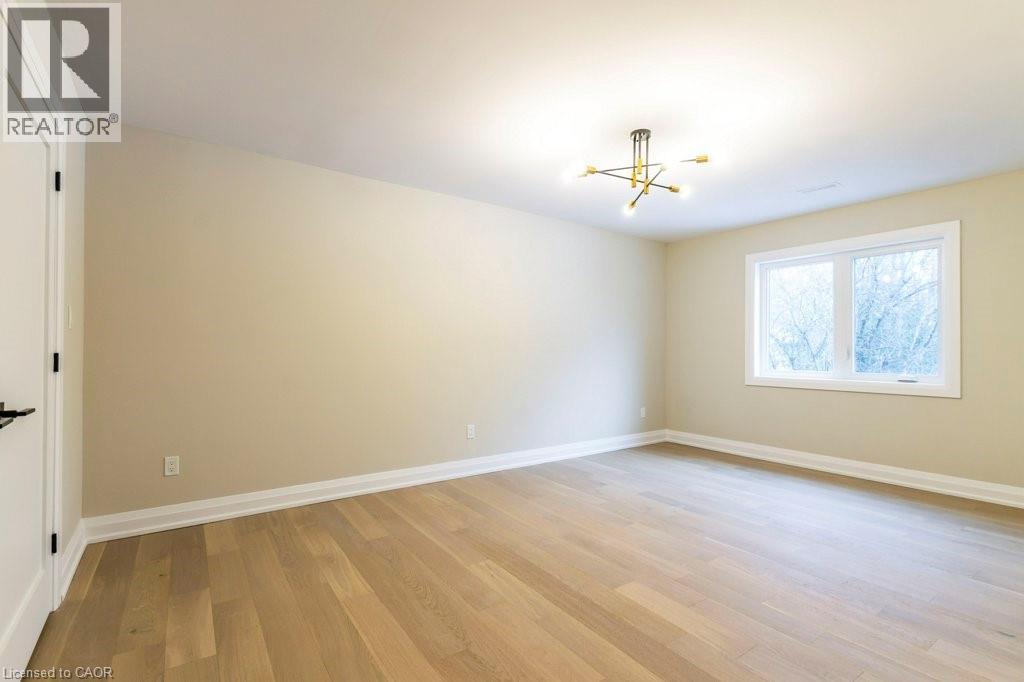 Unfurnished bedroom featuring light wood-style flooring and suspended lighting - 1105 Main Street E, Cambridge, ON - Indoor Photo Showing Other Room