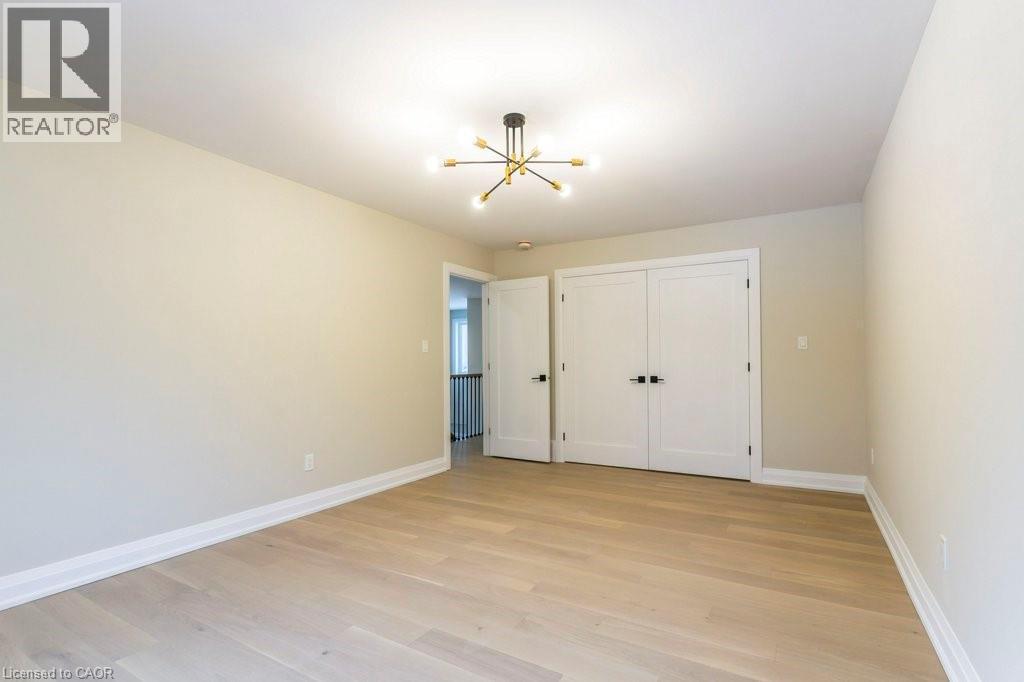 Unfurnished bedroom with light wood-type flooring, a closet, and hanging lights - 1105 Main Street E, Cambridge, ON - Indoor Photo Showing Other Room
