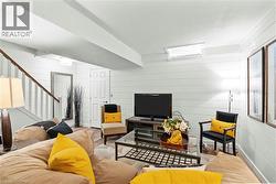 Living area featuring wood-finish flooring and white shiplap walls -
