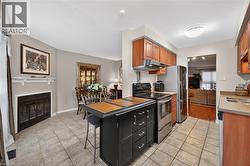 Kitchen featuring an island with wood-finish countertop, stainless steel appliances, and tile flooring -